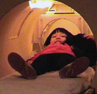 A child practices being in the fMRI machine in the simulator room